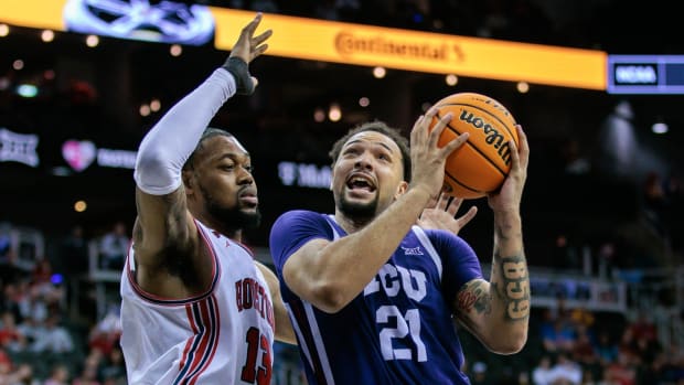 Mar 14, 2024; Kansas City, MO, USA; TCU Horned Frogs forward JaKobe Coles (21) drives to the basket around Houston Cougars forward J'Wan Roberts (13) during the second half at T-Mobile Center. 
